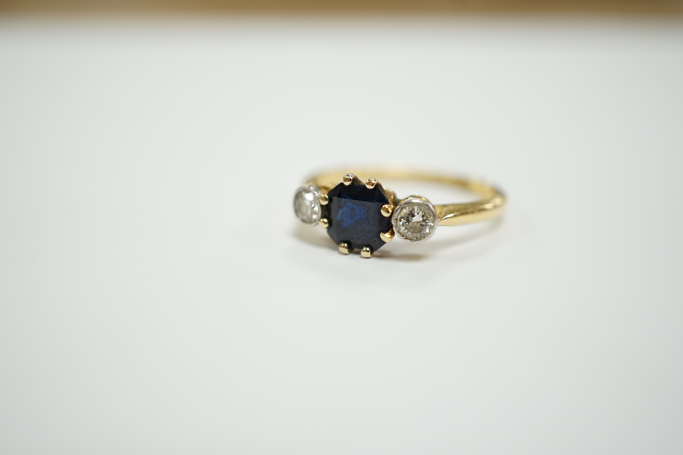 An 18ct and plat, single stone sapphire and two stone diamond set ring, size O/P, gross weight 3.1 grams.